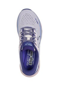 Zapatilla deportiva de color púrpura claro con parte superior de malla, cordones con patrón y suela acolchada. Presenta la marca "SKECHERS" en la plantilla.