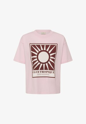 T-shirt rose clair avec un grand graphique de soleil marron et le texte « CLUB TROPIQUE SOUS LE SOLEIL » centré sur le devant.