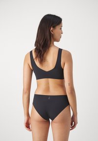 Zwarte naadloze beha en bijpassende high-waisted onderbroek. Heeft een zachte stof, brede bandjes en een minimalistisch ontwerp zonder versieringen.