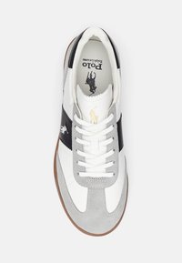 Vita och grå lädersneakers med ett svart rand. Har vita snörningar, en gummisula och en Polo-logga tryckt invändigt.