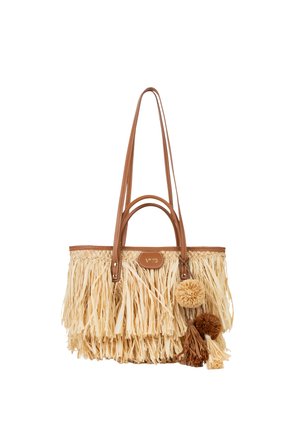 Handtas van gevlochten stro in tan en beige met lange leren handvatten en decoratieve pompons en kwastjes aan de zijkant.