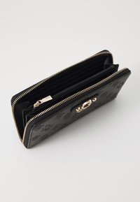 Portefeuille en cuir noir avec motif en relief, fermeture zippée et quincaillerie dorée. Plusieurs compartiments et fentes pour cartes visibles à l'intérieur.