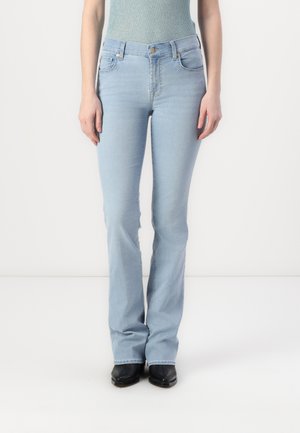 Heledad sinised flare-jeans, mis on valmistatud teksast, kõrge vöökoha, viie tasku ja veidi kulunud viimistlusega. Kombineeritud mustade saapadega.