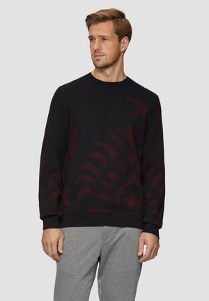 Schwarzer Pullover mit einem bordeauxfarbenen Blumenmuster, Rundhalsausschnitt und gerippten Bündchen; kombiniert mit grauen Jogginghosen für einen lässigen Look.