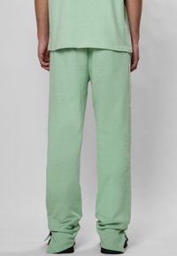 Hellgrüne Sweatpants aus weichem Material mit lockerer Passform, verstellbaren Bündchen und einem schlichten, unauffälligen Design.