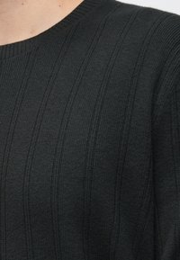 Σκούρο γκρι ριμπ πλεκτό πουλόβερ, με στρογγυλή λαιμόκοψη και υφή με μοτίβο, εμφανείς ραφές και μαλακή υφή.