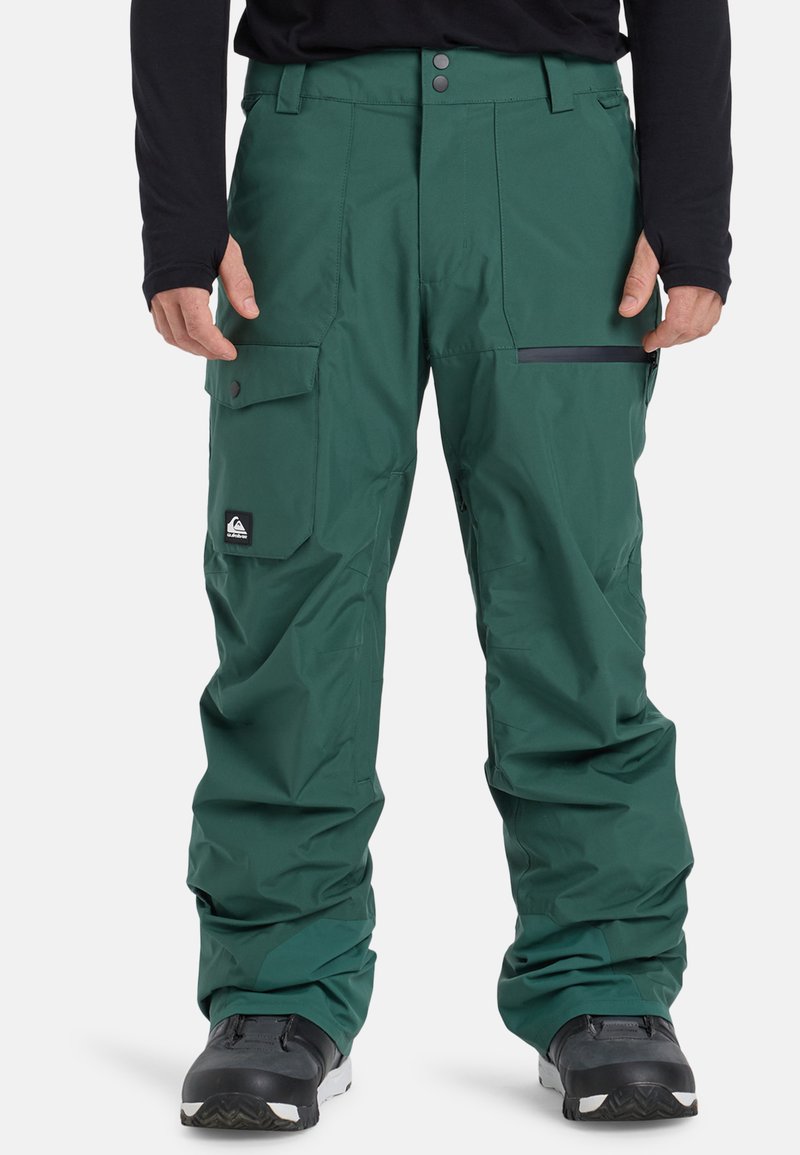 Pantaloni da snowboard verdi con tasca cargo, dettagli neri e vestibilità rilassata. Realizzati in materiale resistente all'acqua per l'uso all'aperto.