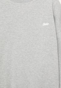 Felpa grigia realizzata in morbido misto cotone, con scollo rotondo e logo ricamato sul petto a sinistra. Tessuto liscio.