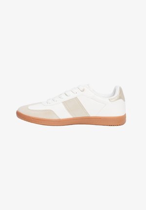 Zapatilla blanca con acentos de ante beige, parte superior de sintético suave, puntera redonda y suela de goma marrón claro. Presenta tres agujeros de lazada.