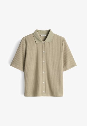 Beiges, kurzärmliges Strickhemd mit vertikaler Rippung, Kragen und weißen Knöpfen auf der Vorderseite, präsentiert vor weißem Hintergrund.