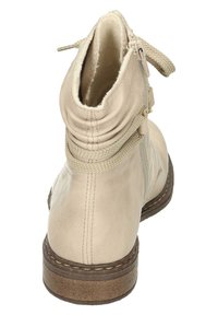 Stivaletto in pelle beige con un design stropicciato, zip laterale e suola in gomma marrone texturizzata. Finitura liscia e lacci a contrasto.