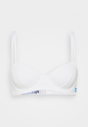 White bra with padded cups, adjustable thin straps, and a horizontal band. Features a textured fabric and a label on the back.