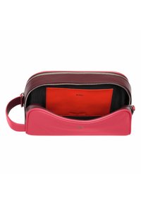 Borsa in pelle rosa con design curvo, chiusura con zip e interno rosso a contrasto. Dispone di un manico singolo e una superficie liscia.