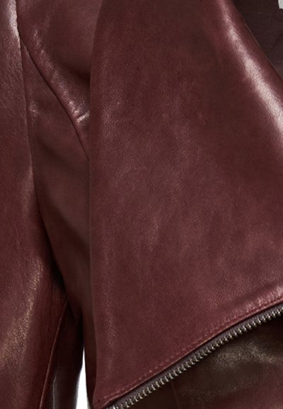 Burgundia nahast jakk, millel on sile tekstuur, asümmeetriline disain ja avatud tõmblukk hemme juures.