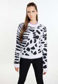 Zwart-wit fluffy sweater met een dierenprintontwerp. Kenmerkt zich door een ronde halslijn en lange mouwen. Gemaakt in combinatie met zwarte broek.