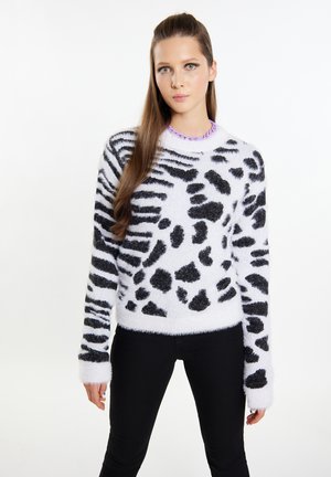 Pulover pufos alb și negru cu design leopard. Are un guler rotund și mâneci lungi. Purtați-l cu pantaloni negri.