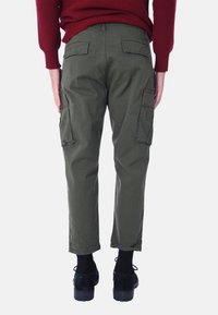 Pantaloni cargo in verde oliva, con multiple tasche laterali, taglio dritto e una lunghezza leggermente cropped. Realizzati in tessuto durevole.