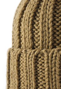 Berretto lavorato a maglia realizzato in un spesso filato color tan, caratterizzato da una texture a costine con motivi verticali e un orlo piegato alla base.