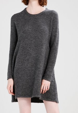 Robe pull tricotée gris foncé avec des manches longues, un col rond et un ourlet légèrement asymétrique. Texture douce avec des détails de design minimaux.