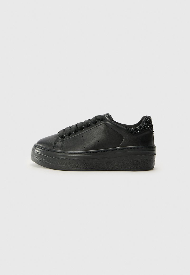Sneakers in pelle nera con suola platform testurizzata, punta rotonda e lacci frontali. Tallone posteriore decorato con borchie nere.