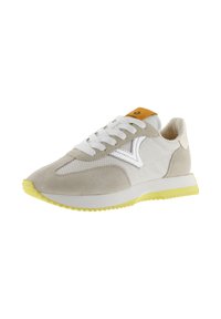 Sneakers en daim et maille gris clair avec un logo blanc et une semelle extérieure jaune. Présente des lacets blancs et une languette jaune et grise.