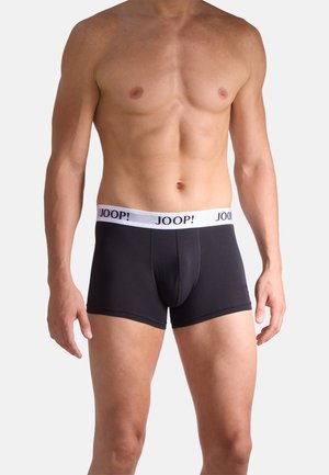 Torso masculino sin camiseta que lleva puestos bóxers ajustados negros con una cintura blanca que muestra el logo "JOOP!".