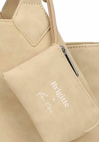 Beige faux suede handtas met een bijpassend afneembaar zakje, voorzien van een ritssluiting en een wit reliëflogo.