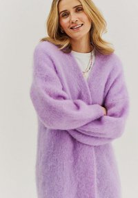 Levanduľový nadmerný sveter z jemnej, chlpaté látky s dlhými rukávmi a otvoreným predným dielom, s pohodlným strihom a jemnou textúrou.