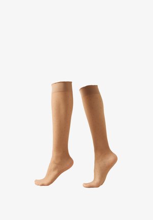 Medias hasta la rodilla de color nude con una textura suave y un pequeño patrón de lunares, que cuentan con una banda ancha y suave en la parte superior.
