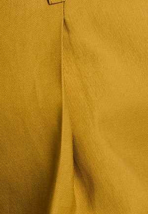 Tessuto giallo intrecciato con una texture a coste, che mostra una finitura liscia e una leggera lucentezza. Il materiale è resistente e strutturato.