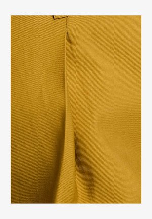 Tela amarilla tejida con una textura acanalada, que muestra un acabado suave y un brillo sutil. El material es duradero y estructurado.