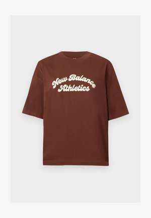 Brūns kokvilnas T-krekls ar brīvu piegriezumu, uz kura ir balts uzraksts "New Balance Athletics" izliekta, treknā fontā.