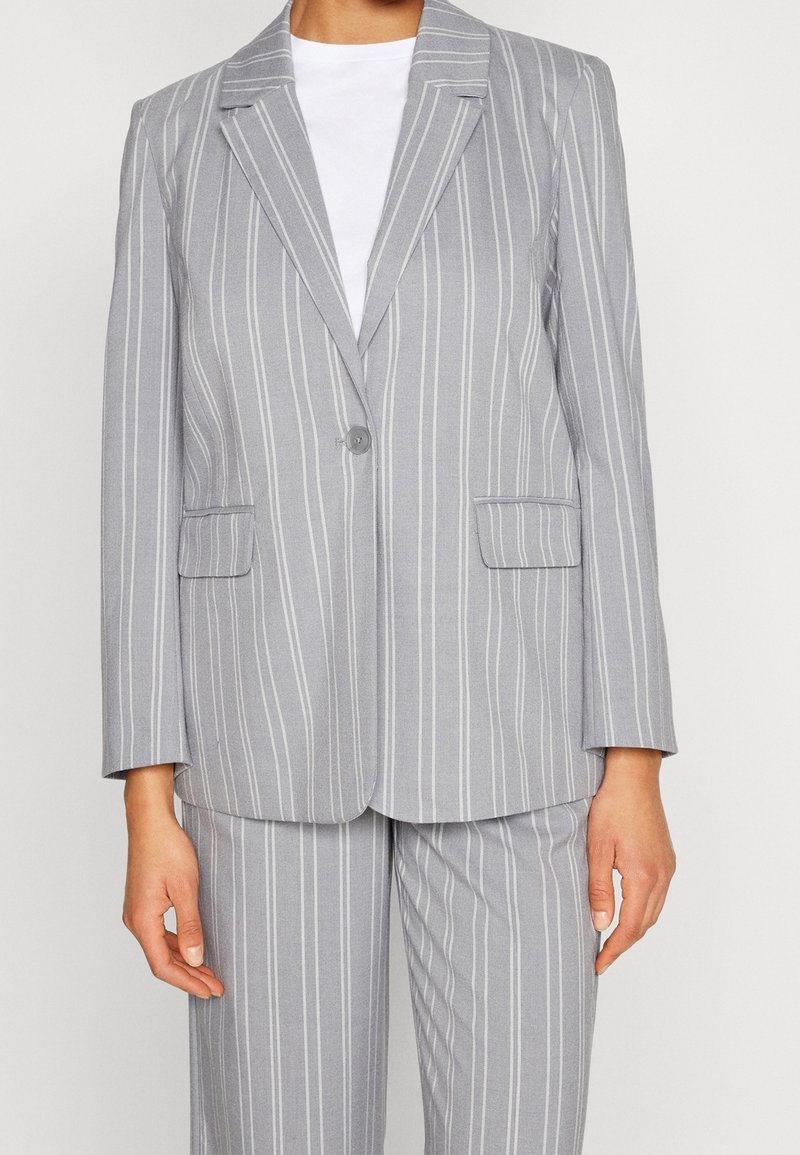 Grå randig blazer med en kavajslag med hack, enkelknäppt stängning och två framfickor. Slätt tyg, skräddarsydd passform och långa ärmar.