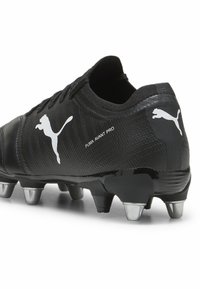 Czarne korki piłkarskie Puma Avant Pro z teksturowanym wierzchem, białym logo i srebrnymi korkami dla lepszej przyczepności. Elegancki design o niskim profilu.