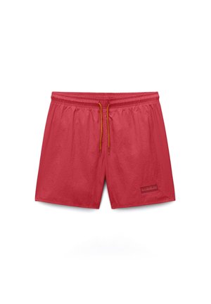 Bañador de cintura elástica roja con cordón naranja y pequeño parche de logo en la parte inferior de la pierna izquierda sobre fondo blanco.