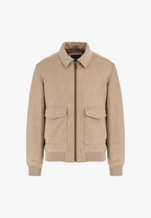 Beige wollen jack met rits, twee voorzakken met klep, geribde boorden en onderrand, en een kraag. Heeft een logo-label op de linkse pocket.