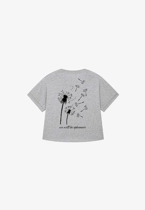 Graues T-Shirt mit kurzen Ärmeln, bedruckt mit einer schwarzen Löwenzahn-Illustration und dem Satz "wir werden vergänglich sein" auf der Rückseite. Weicher Stoff und entspannter Schnitt.