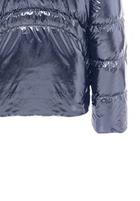 Nahaufnahme eines glänzenden schwarzen Steppjackenärmel und des unteren Rückenbereichs mit horizontaler Steppnaht und reflektierender Oberfläche.