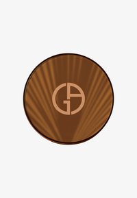 Bronse sirkulær kompakt med en reflekterende overflate. Har en hevet logo i en lysere bronsefarge. Subtil radial mønster synlig.