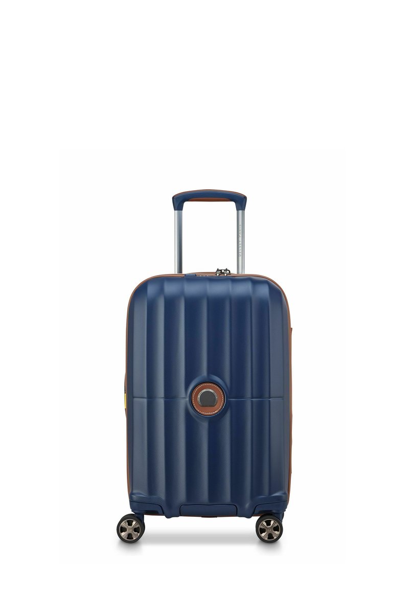 Maleta rígida de color azul marino con un diseño estriado, acentos marrones, mango retráctil y cuatro ruedas para mayor movilidad.
