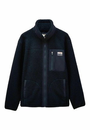 Mörkblå fleecjacka med hög krage, hel dragkedja fram, en dragkedjeförsedd bröstficka med logotyp och två sidofickor.