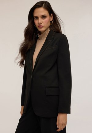 Zwarte blazer met een enkele knoop, een notch revers en een borstzak. Heeft bruine stikseldetails en is gemaakt van een gladde stof.