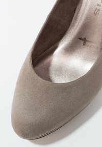 Chaussure plate pour femme en daim taupe avec bout arrondi et semelle intérieure métallique rembourrée.