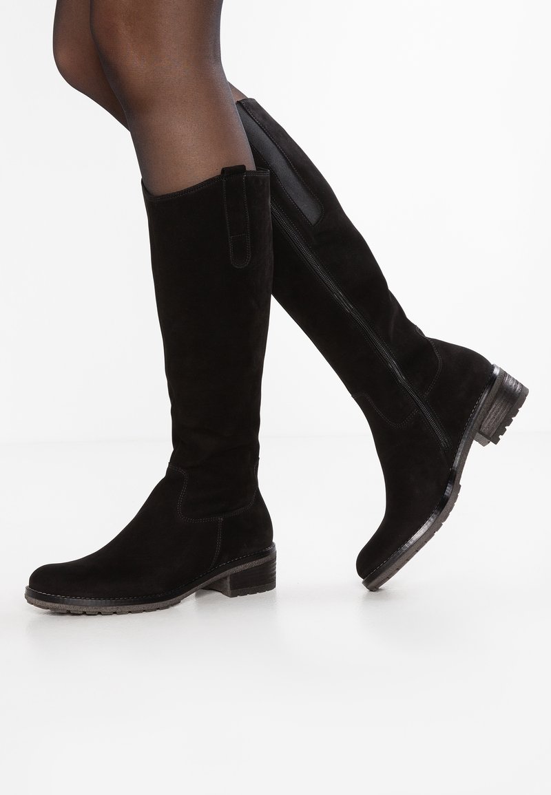Bottes en daim noir montant au-dessus du genou avec un bout légèrement arrondi, un talon texturé, une fermeture éclair latérale visible et une bride de traction supérieure.