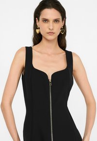 Černé bodycon šaty s hlubokým V-výstřihem a zlatým zipem. Vyrobeno z hladké látky, s širokými ramínky a přiléhavým střihem.