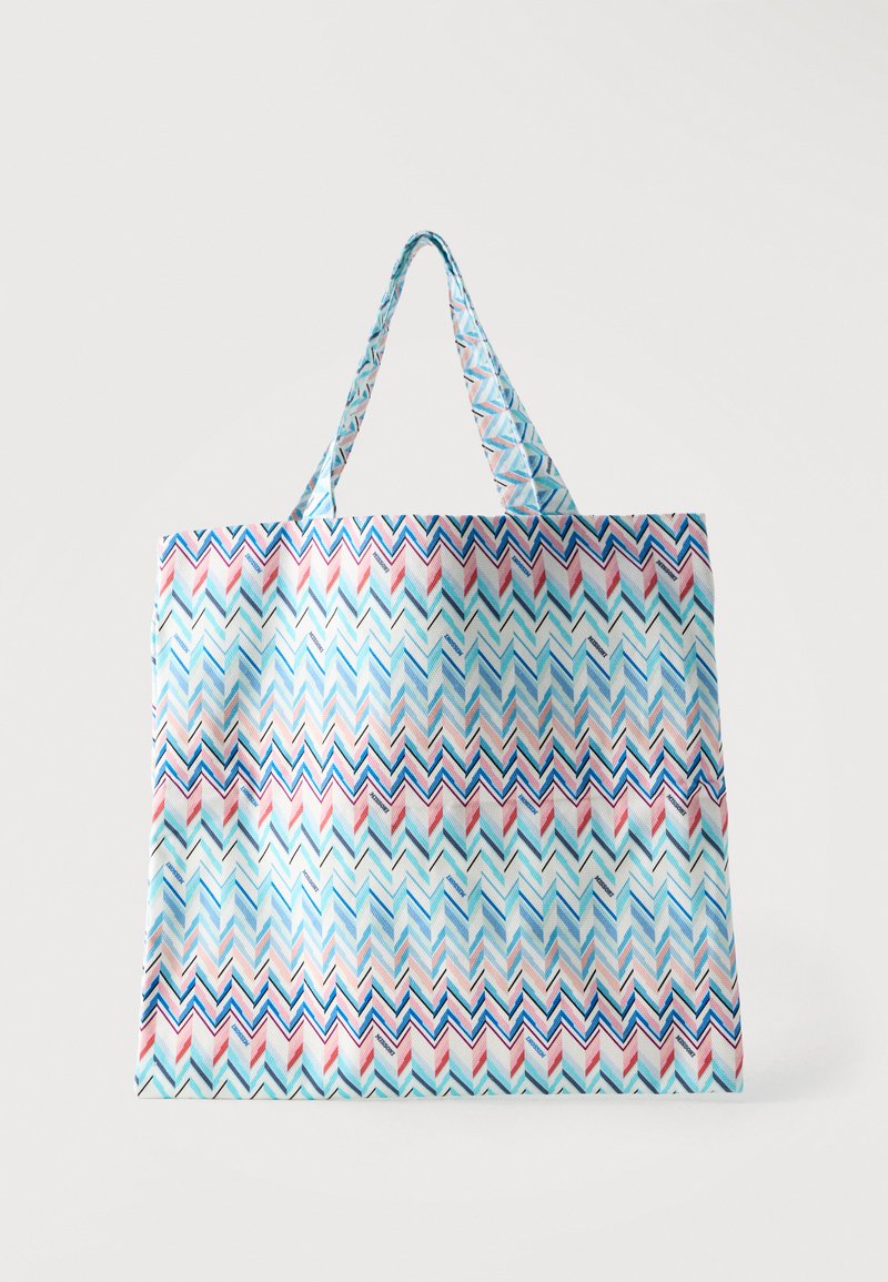 Επαναχρησιμοποιήσιμη τσάντα tote με μπλε, ροζ και λευκό σχέδιο ζιγκ ζαγκ και ταιριαστά χερούλια, τοποθετημένη σε απλό λευκό φόντο.