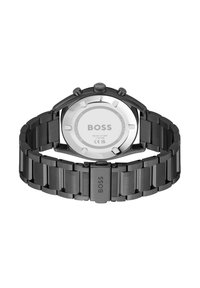 Montre en acier inoxydable noir avec un dos poli, trois boutons de chronographe et un bracelet maillon. Affiche la marque "BOSS" sur le fermoir.