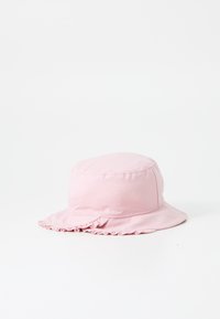 Rosa bucket hat i mjukt tyg med en rund ovansida och en vågig kant. Har en enkel, sömlös design och en lätt textur.