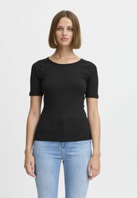 Top corto a maniche corte nero a coste con scollatura rotonda, design aderente e texture liscia, abbinato a jeans in denim azzurro chiaro.
