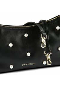 Borsa a tracolla in pelle nera decorata con perle bianche sparse, cerniera dorata, tracolla rimovibile con fibbie dorate e logo "Coccinelle" in lettere dorate.